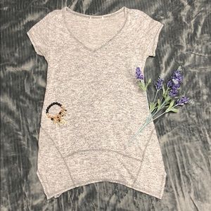 Long, light gray, short sleeved unique top.